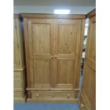A pine double door wardrobe fitted a drawer