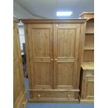 A pine double door wardrobe fitted a drawer