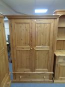 A pine double door wardrobe fitted a drawer