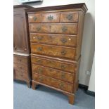 A George II walnut nine drawer chest on chest with brass drop handles on bracket feet