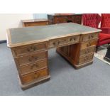 A Victorian oak twin pedestal partner's desk fitted nine drawers on both sides,