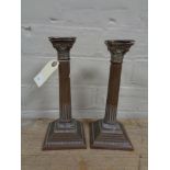 A pair of antique copper Corinthian column candlesticks