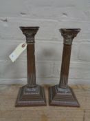 A pair of antique copper Corinthian column candlesticks