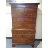 A George III inlaid mahogany chest on chest with brass drop handles raised on bracket feet