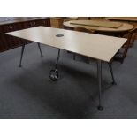 An office table on metal legs fitted with central power points,