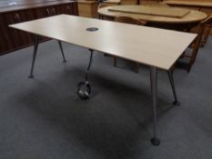 An office table on metal legs fitted with central power points,