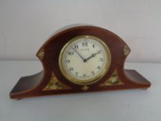 An early twentieth century inlaid Swiss mantel clock on brass feet