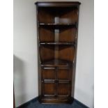 An Ercol corner cupboard fitted with shelves