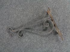 An antique cast iron wall bracket with hook