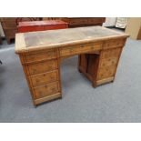 A Victorian Aesthetic period oak writing desk with nine drawers and tooled leather inset panel