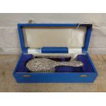 A cased silver backed baby brush with silver edged comb in fitted box