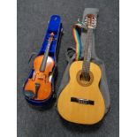 A student violin and bow in case together with an acoustic guitar in carry bag