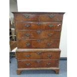 A George II walnut seven drawer chest on chest with brass drop handles