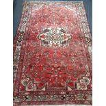 A fringed Iranian Hamadan rug on red ground