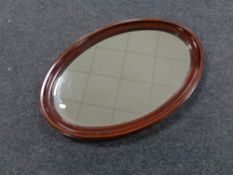 A Victorian inlaid mahogany oval bevelled edge mirror