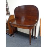 A mahogany demi lune turnover top tea table on reeded legs