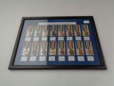 A set of sixteen framed Victory miniature medals in display frame