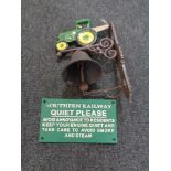 A cast iron tractor wall bracket with bell and a railway safety notice