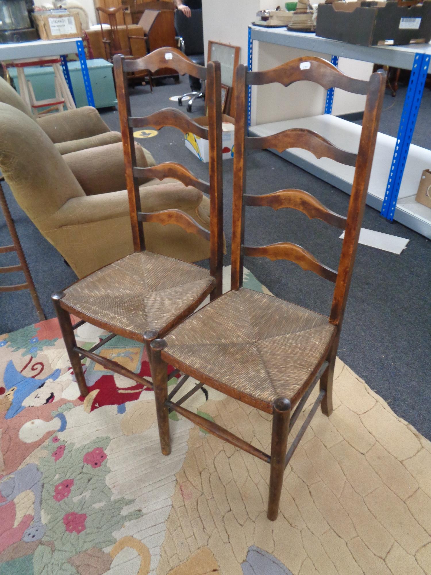 A pair of antique ladder back country kitchen chairs