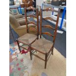 A pair of antique ladder back country kitchen chairs