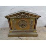 An antique brass cased mantel clock with figural decoration