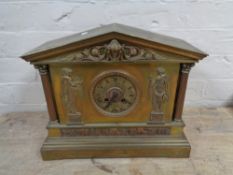 An antique brass cased mantel clock with figural decoration