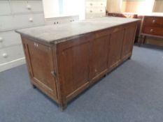 An early 19th century pine farmhouse kitchen table fitted with proving cupboard and three drawers