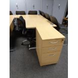 A corner office desk with three drawer pedestal and swivel adjustable armchair