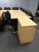 A corner office desk with three drawer pedestal and swivel adjustable armchair