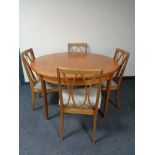 A circular teak G Plan extending table and four chairs