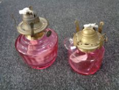 Two antique cranberry glass oil lamps