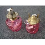 Two antique cranberry glass oil lamps