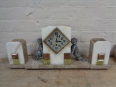 A three piece marble Art Deco clock garniture with pendulum and key