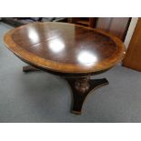 An oval twin pedestal dining table in walnut finish