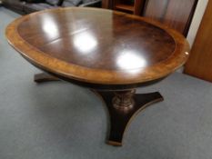 An oval twin pedestal dining table in walnut finish