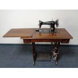 A mid 20th century Singer treadle sewing machine in table