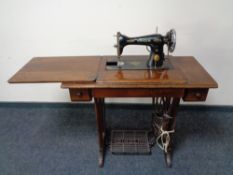 A mid 20th century Singer treadle sewing machine in table