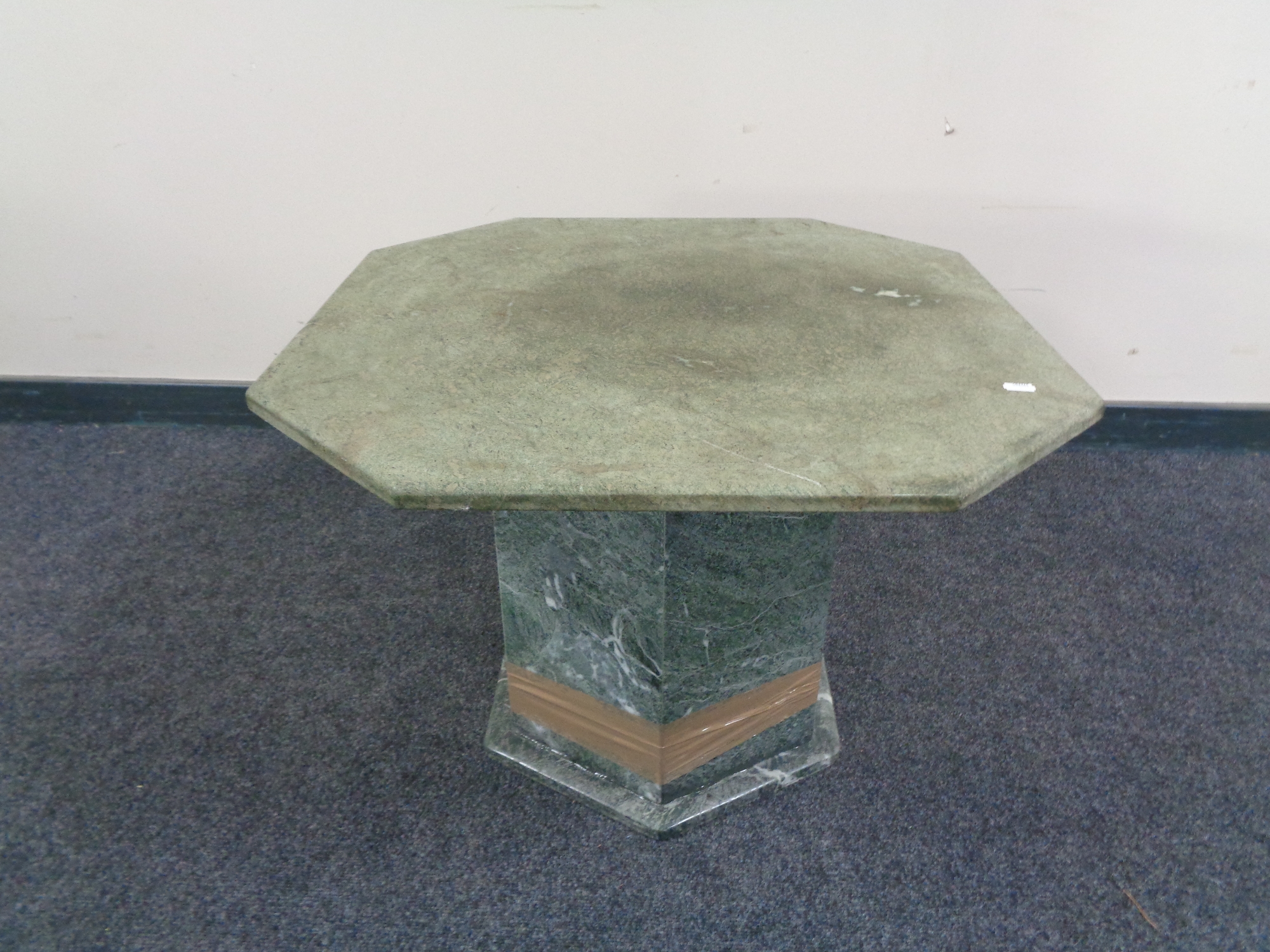 An octagonal marble pedestal coffee table