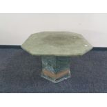 An octagonal marble pedestal coffee table