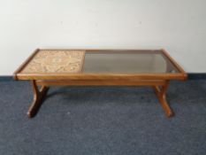 A mid 20th century teak tiled topped and smoke glass coffee table