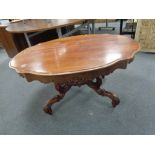 A shaped continental mahogany coffee table on pedestal