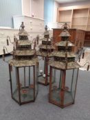 Three metal hexagonal candle lanterns in the form of Chinese pagodas.