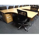 A corner office desk with three drawer pedestal and swivel adjustable armchair