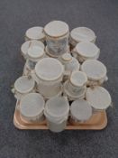 A tray of twenty antique glazed pottery marmalade and potted meat jars