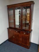 A reproduction inlaid mahogany triple door display cabinet fitted with cupboards and drawers