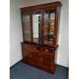 A reproduction inlaid mahogany triple door display cabinet fitted with cupboards and drawers