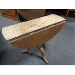 A Victorian oak drop leaf table on three way pedestal