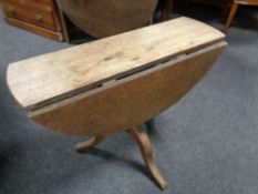 A Victorian oak drop leaf table on three way pedestal