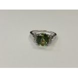 A silver dress ring set with a green stone,