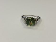 A silver dress ring set with a green stone,